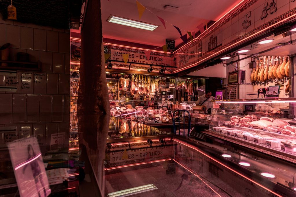 Metzgerei mit hängendem Fleisch und Neonlichtern