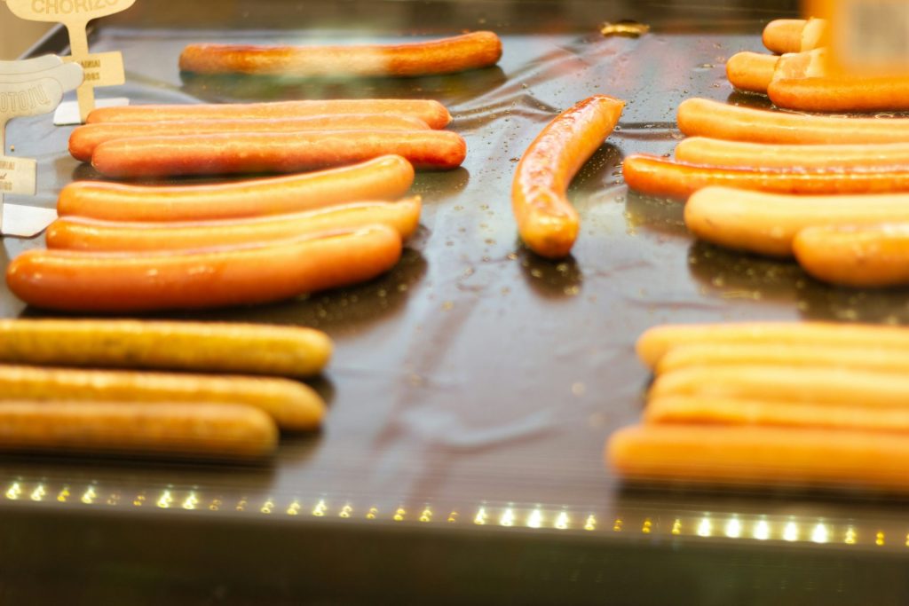 Ein Haufen Hotdogs liegt auf dem Grill